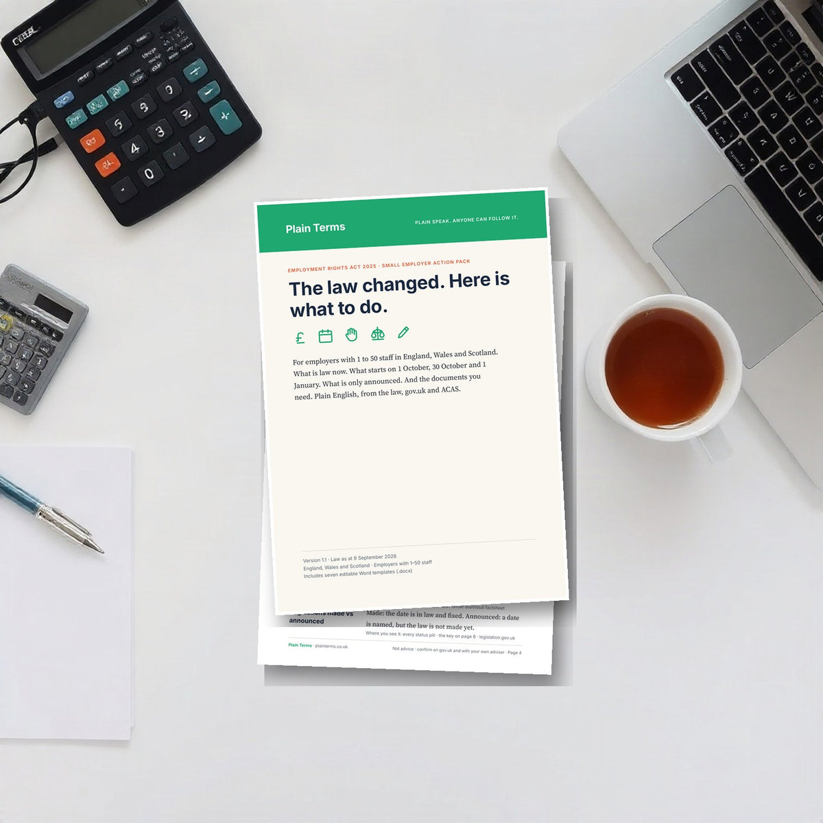 The Employment Rights Act employer pack printed on an office desk beside a laptop and calculator