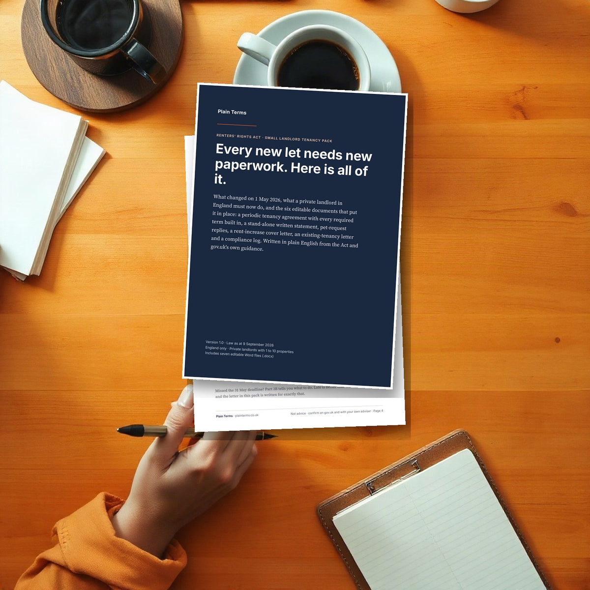 A landlord reading the Renters' Rights Act tenancy pack at a kitchen table with a pen and coffee